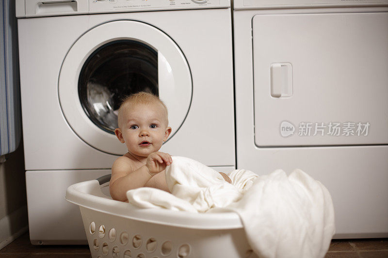 小男孩在洗衣篮里玩