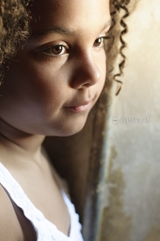 美丽的肖像7岁女孩站在窗前