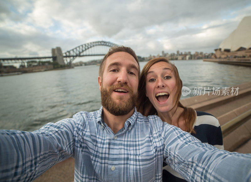 一对年轻夫妇在悉尼港拍自拍照