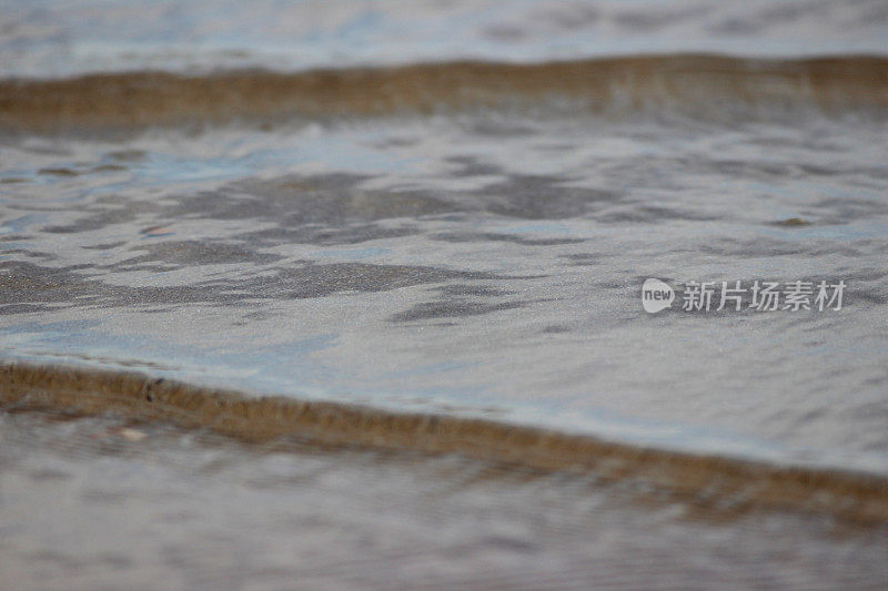 温柔的海浪拍打海滩海岸的特写图像