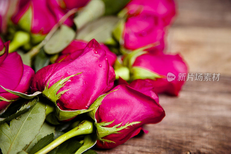 情人节快乐。特写镜头。粉红色的玫瑰花束。乡村的木桌上。
