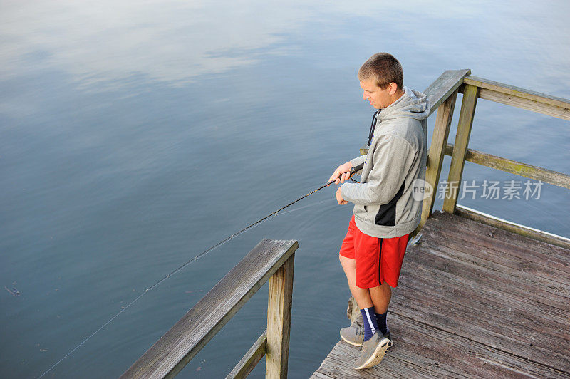 一个年轻人在码头上钓鱼