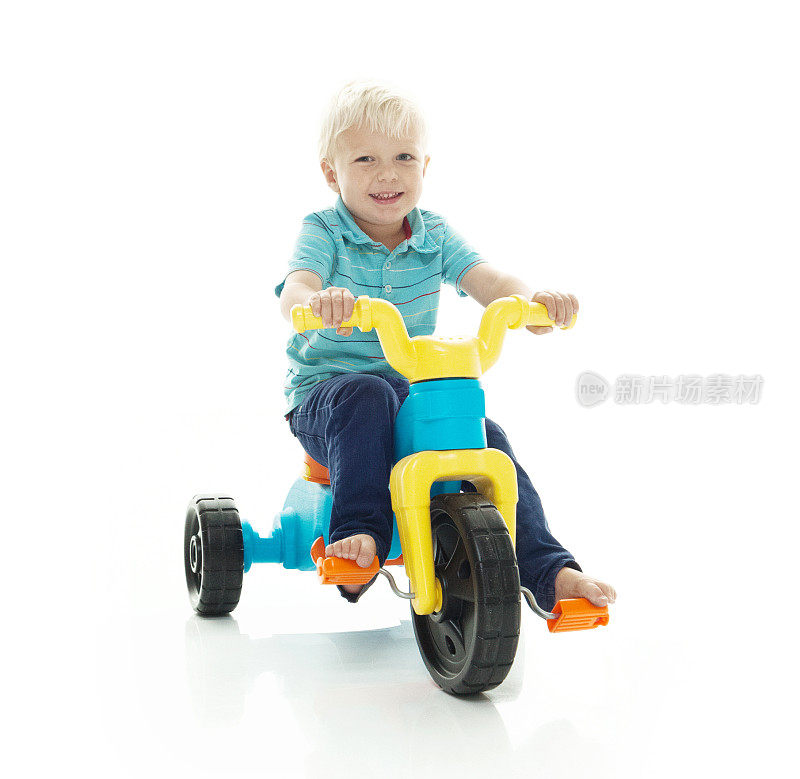 微笑的小男孩骑着三轮车