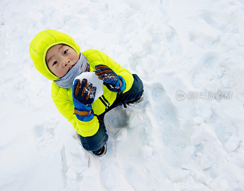 一个亚洲男孩在雪地里玩