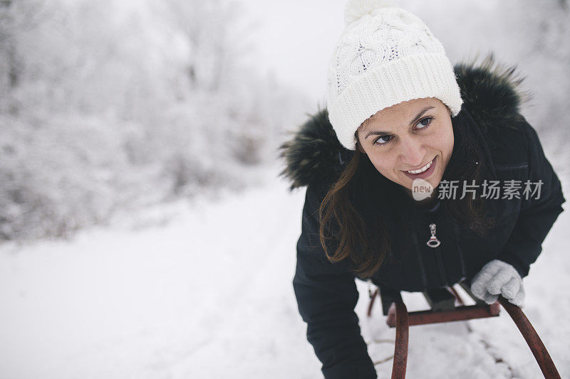 年轻女子在深雪中玩雪橇