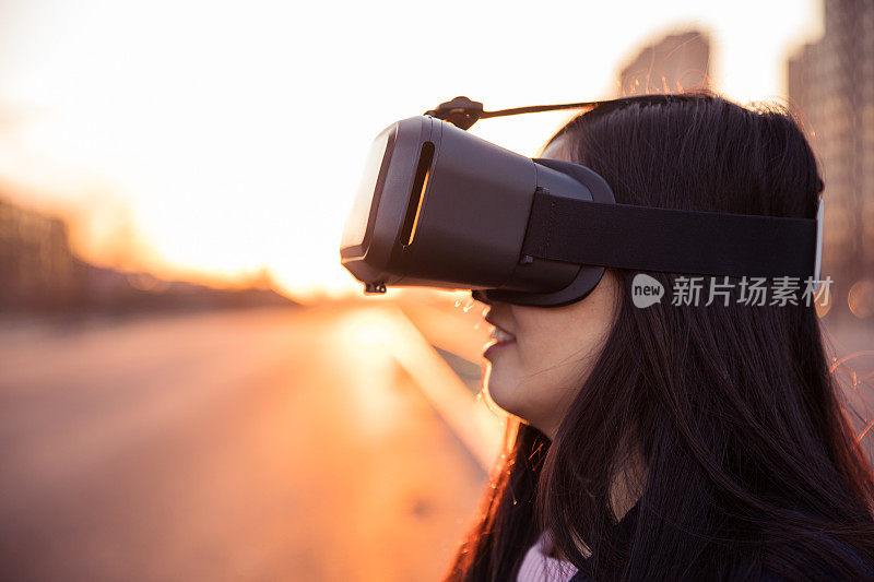 女人在日落时使用虚拟现实头盔