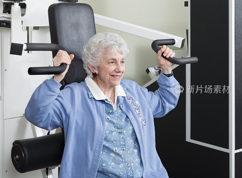 老年妇女使用手臂举重机