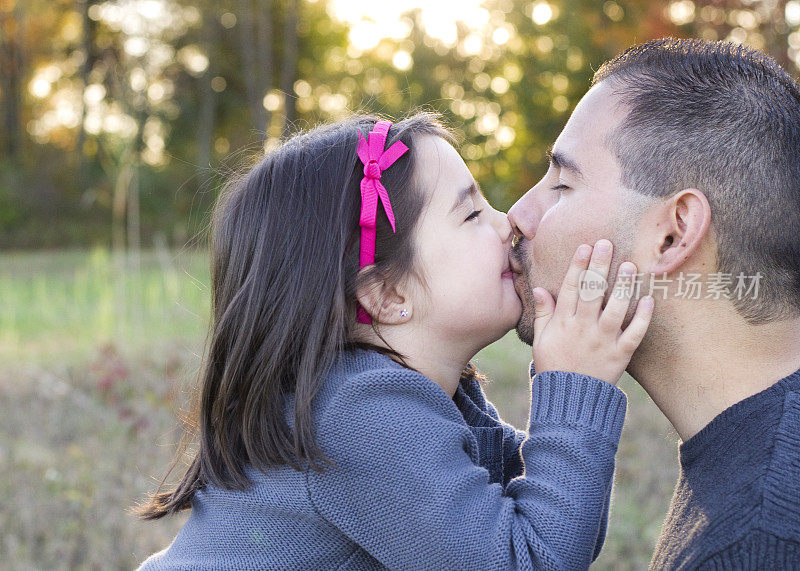 爸爸和女儿用手在脸颊上亲吻