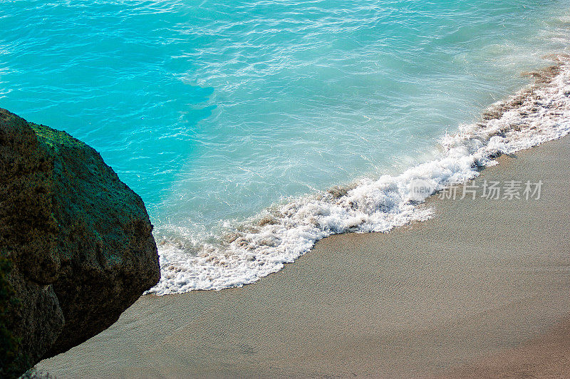 蔚蓝的海浪在热带海滩上溅起水花