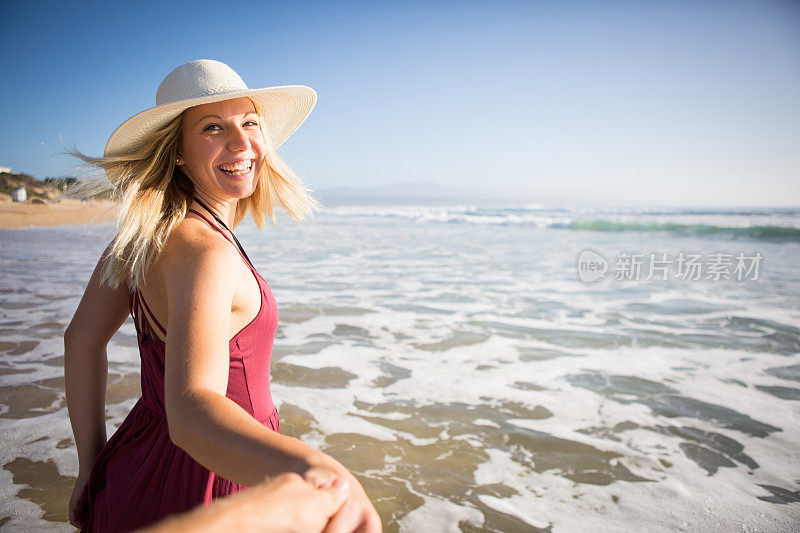 戴太阳帽的女人享受她在海滩上的时光