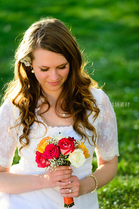 美丽的新娘看着花束-垂直