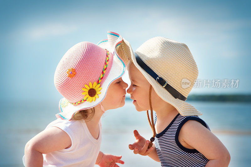 小女孩和小男孩在沙滩上接吻