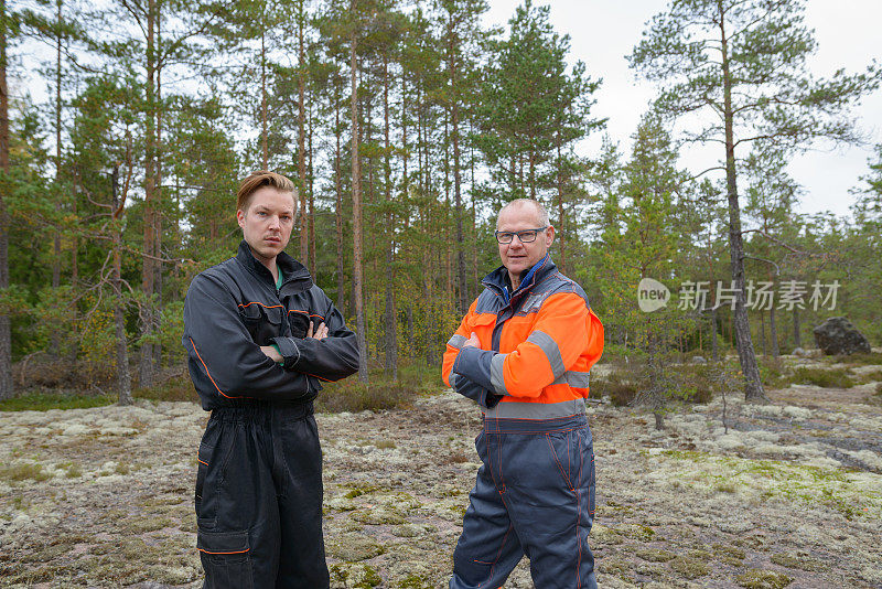 一个成熟的男人和一个年轻的男人一起在森林里工作
