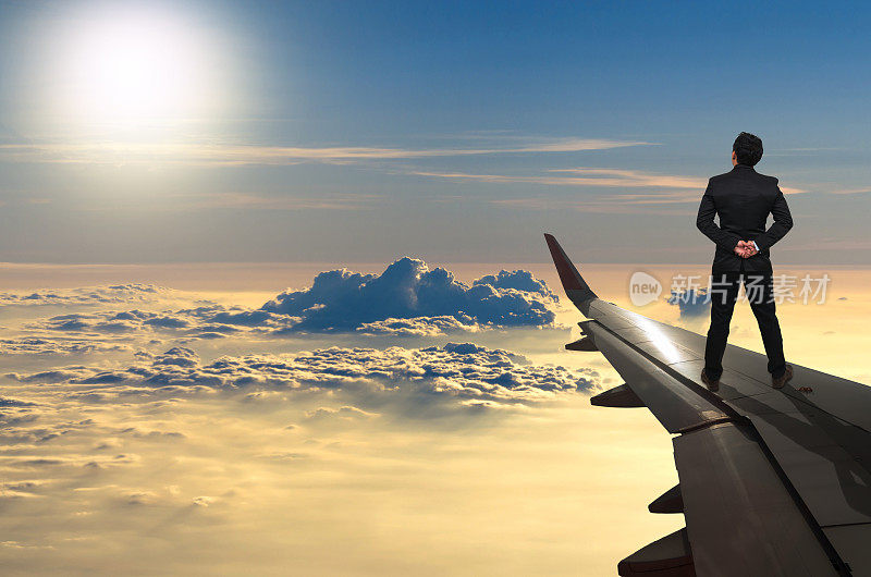 站在飞机机翼上看日落的商人，挑战商业理念