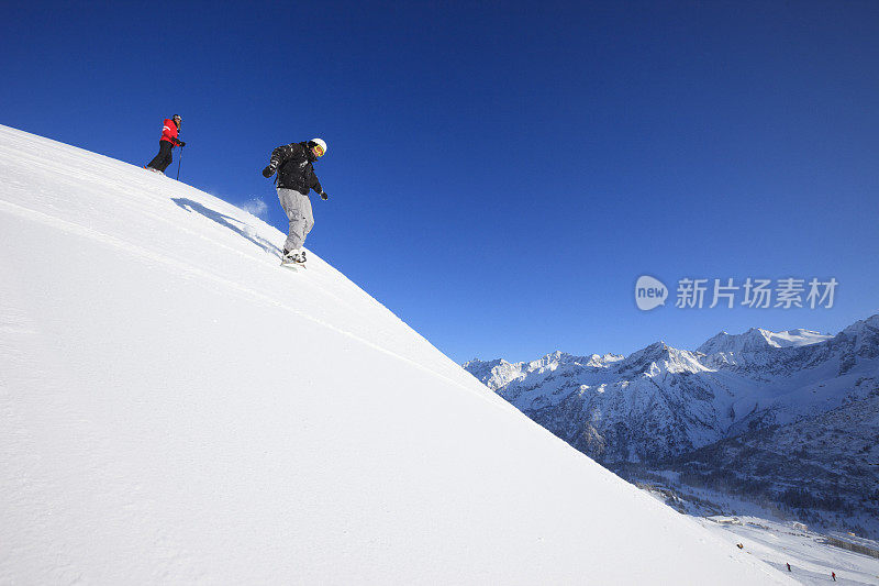 年轻男子滑雪板和女子滑雪者滑雪在阳光明媚的滑雪胜地Dolomites在意大利业余冬季运动