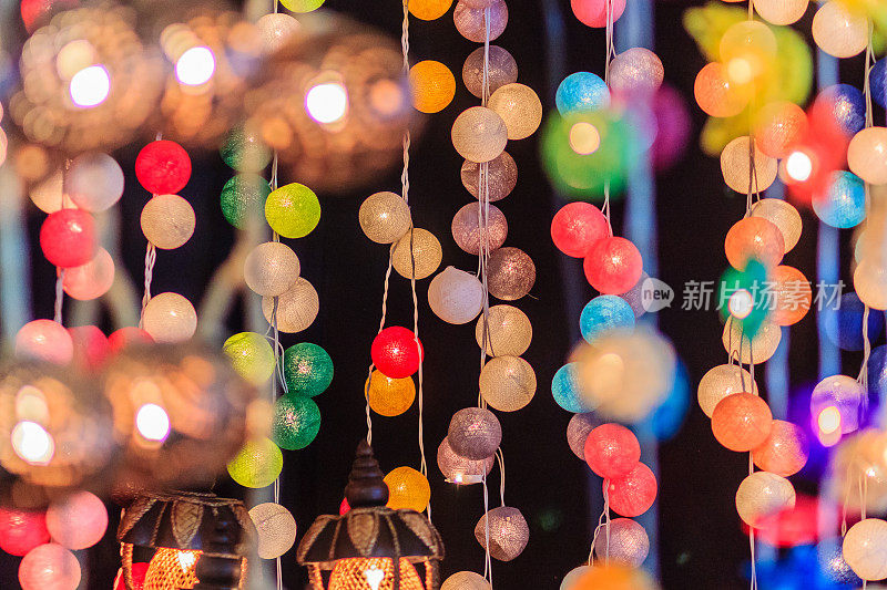 美丽的幕线LED照明与散景在晚上。抽象线LED光散焦背景。五颜六色的装饰LED灯在泰国曼谷夜市出售。
