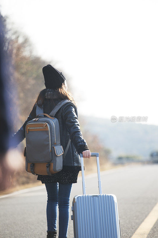 女人拖着行李离开