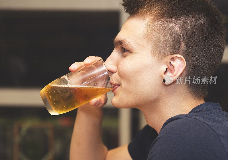 一个男人喝啤酒的特写