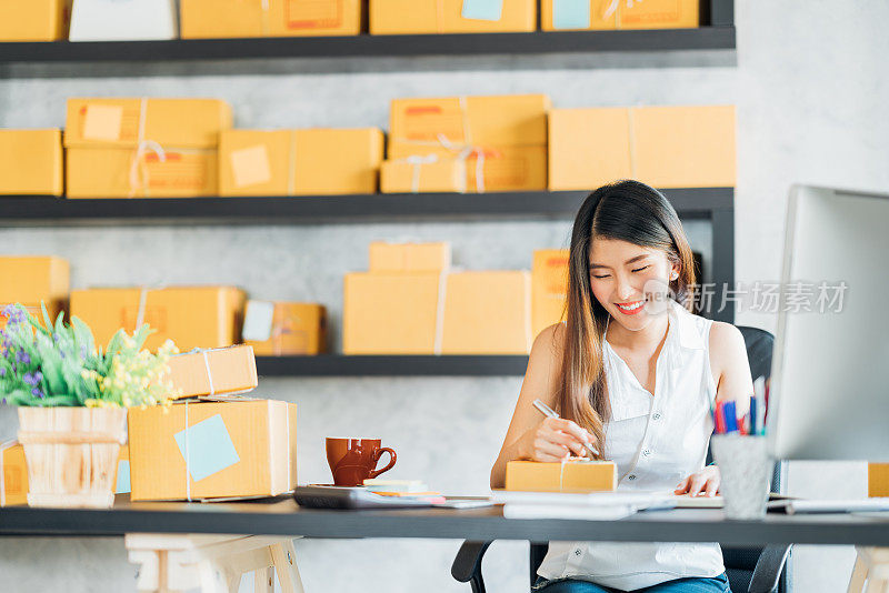 年轻的亚洲小企业主在家办公，记录采购订单。网上营销包装配送，创业中小企业或自由职业女性概念