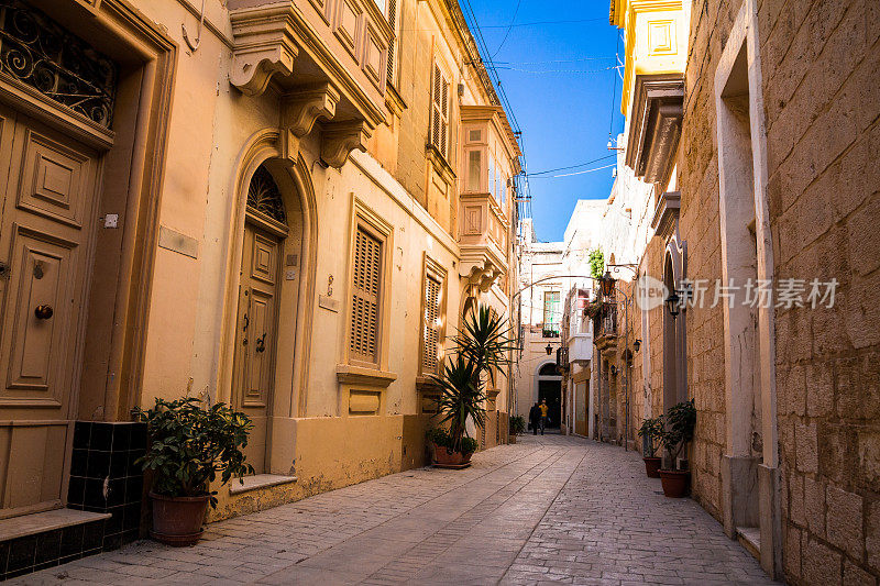 马耳他Mdina，人们走在阳光明媚的狭窄街道上