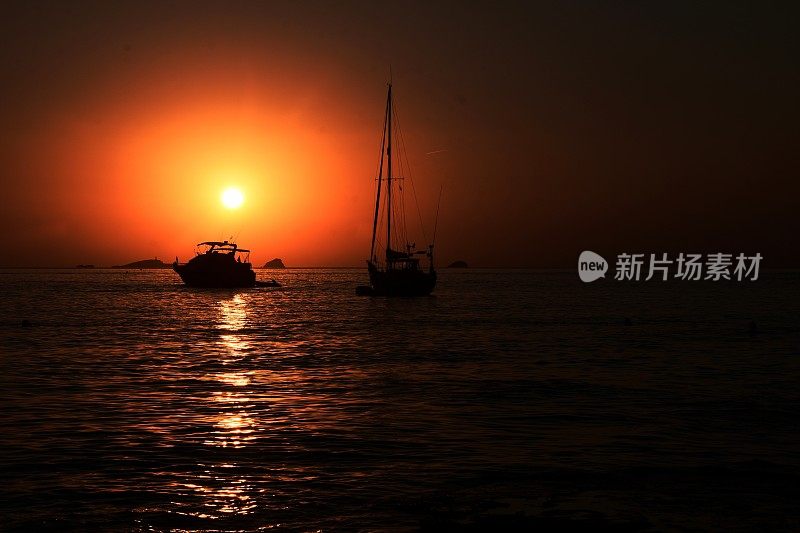 海上的船在夕阳的映衬下