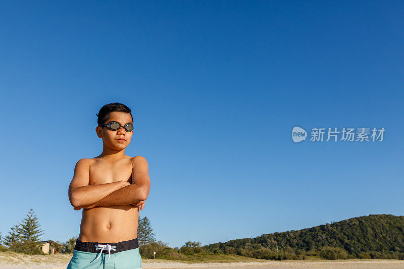 澳大利亚土著男孩与冲浪板在海滩上