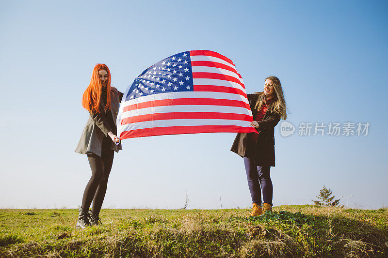 两个女孩举着美国国旗