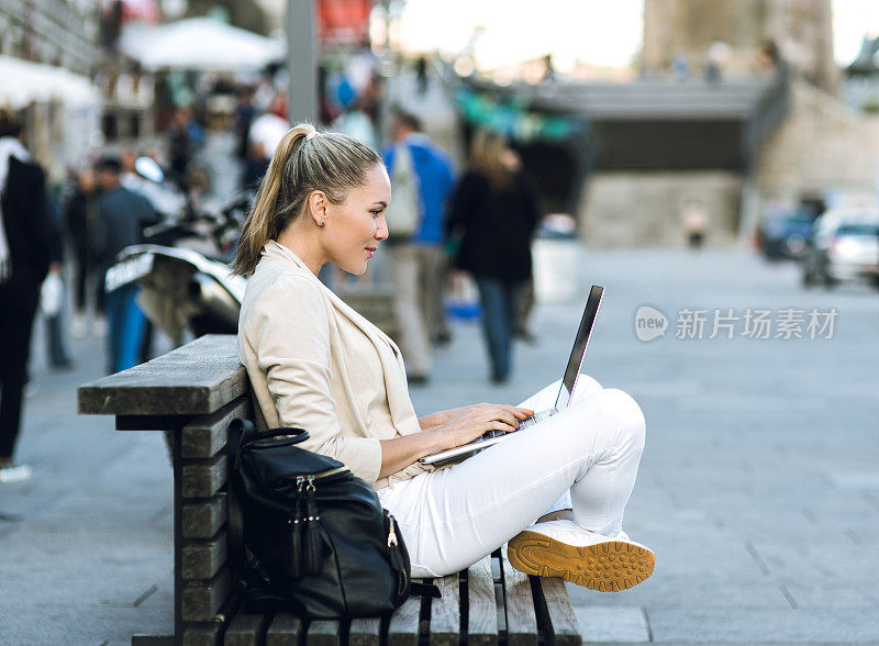 一个女人在街上用笔记本电脑