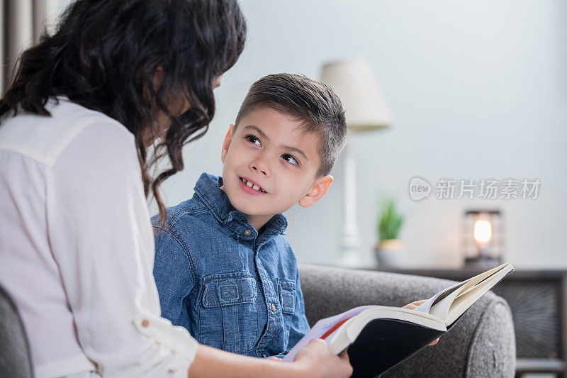 小学时代的小男孩和他的妈妈一起在家里看书