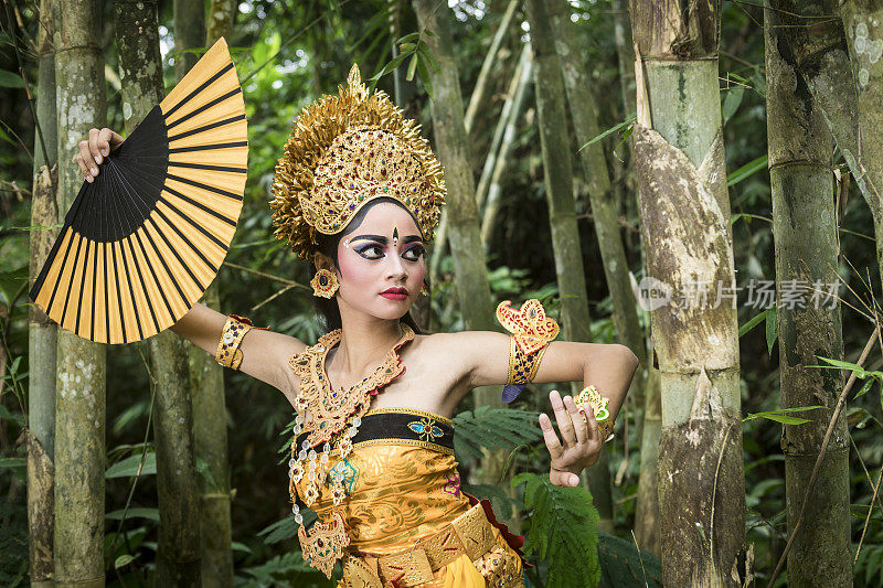 年轻的传统巴厘岛舞者在竹林里