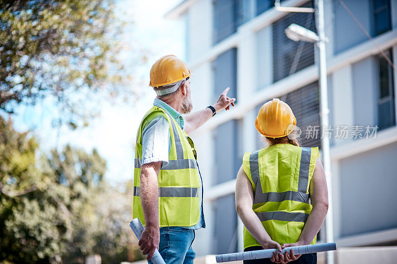 男性和女性建筑专业人员仰望建筑