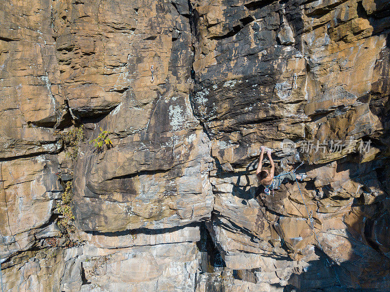 一个中年男人在一个极端的位置攀岩的鸟瞰图