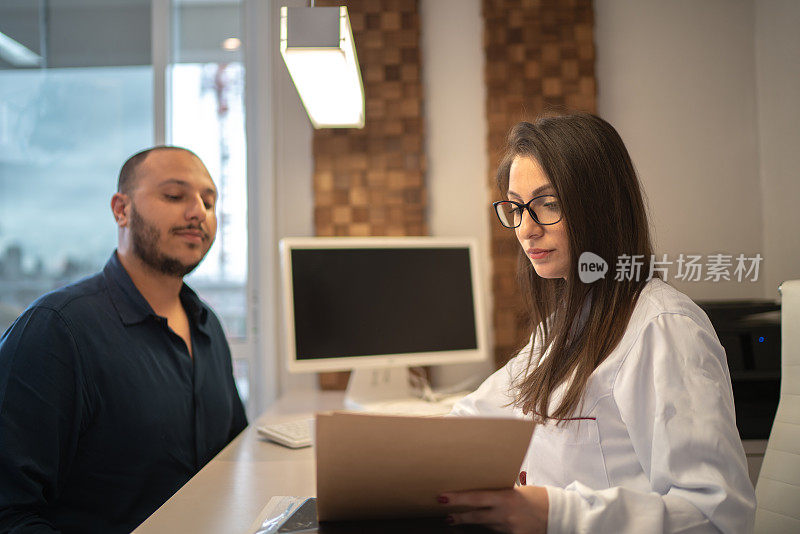 女医生在诊所给病人看结果