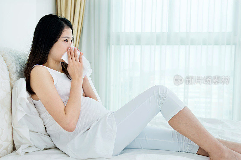 孕妇在床上擤鼻涕