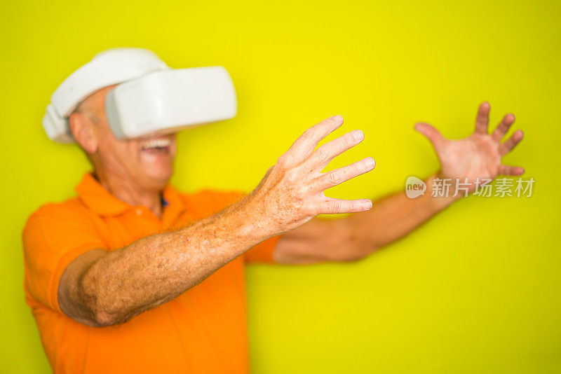 一个戴着虚拟现实眼镜的老人伸出手臂盯着自己的手