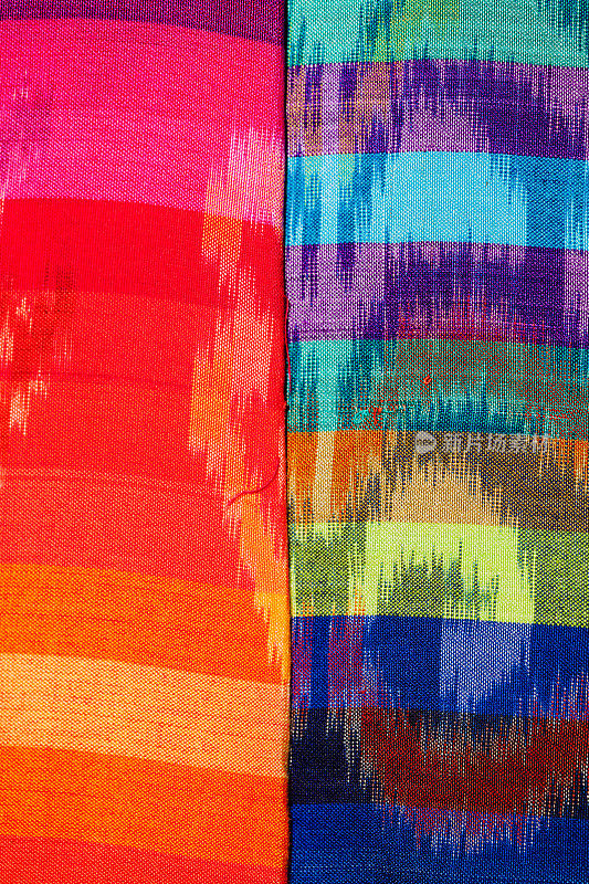 在巴厘岛乌布的印尼纺织品市场选择两种伊卡特面料