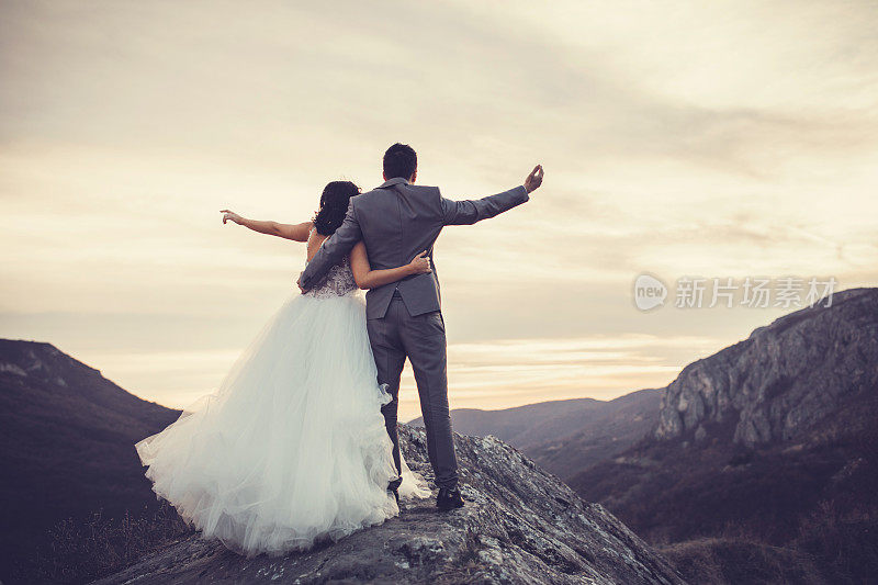 一对新婚夫妇站在山顶上