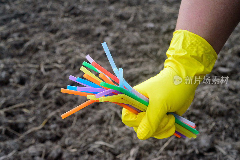 手持塑料吸管手套的手的特写——生态产业理念