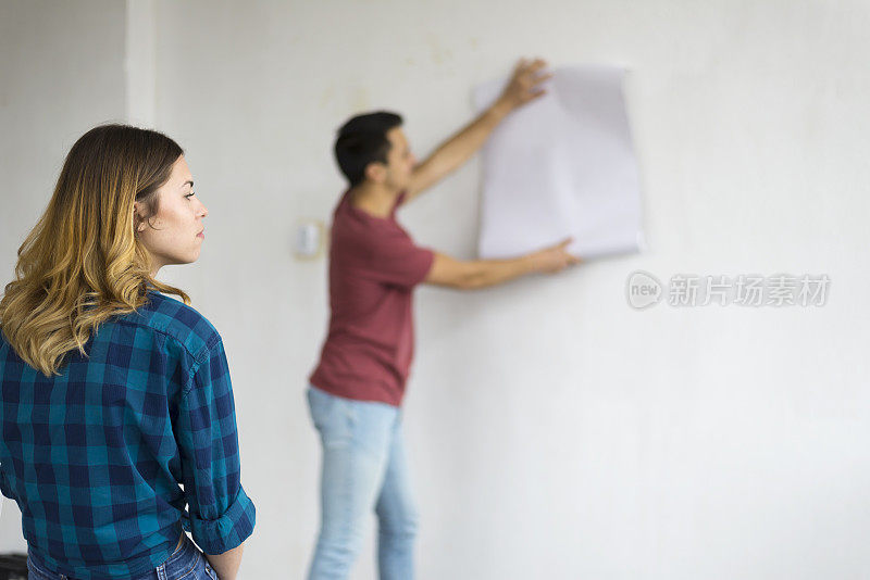 一对相爱的年轻夫妇，为他们的新家选择壁纸。