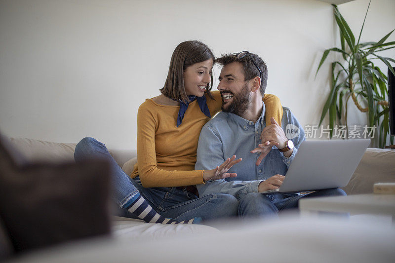 年轻夫妇在客厅里用一台电脑