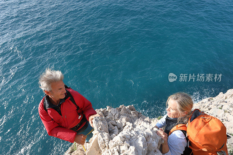 在地中海上攀爬岩石的夫妇