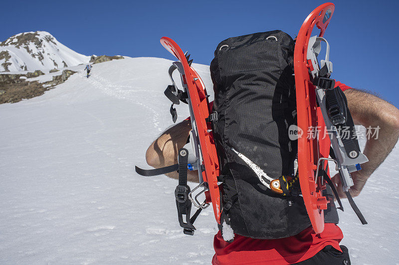 一个穿着雪鞋在雪地上行走的登山运动员