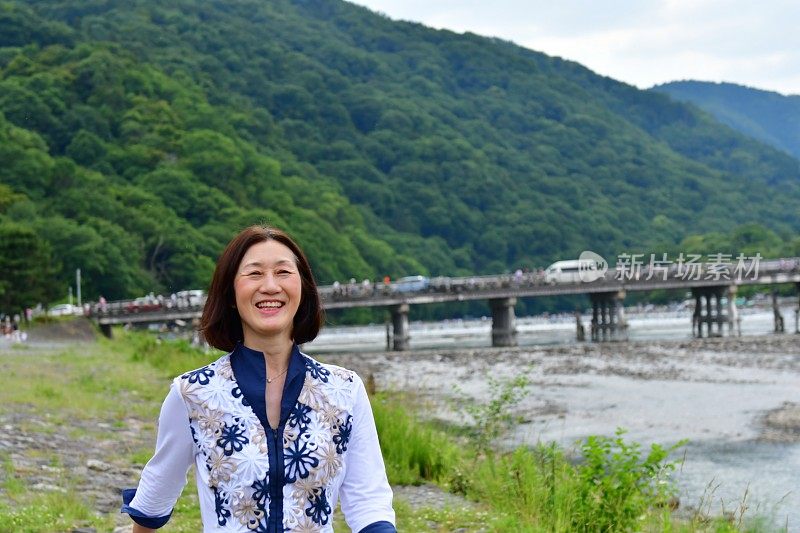行走在京都岚山河畔的日本妇女