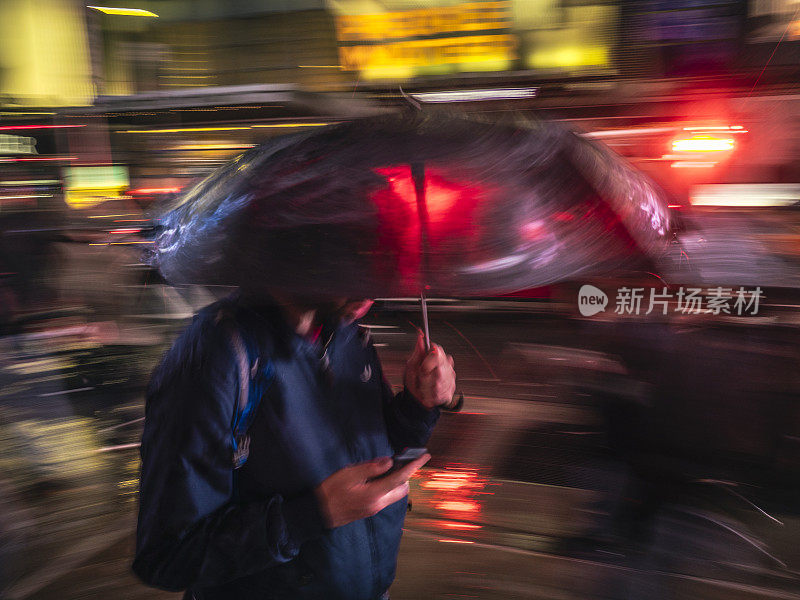 在曼哈顿带着雨伞行走的男人