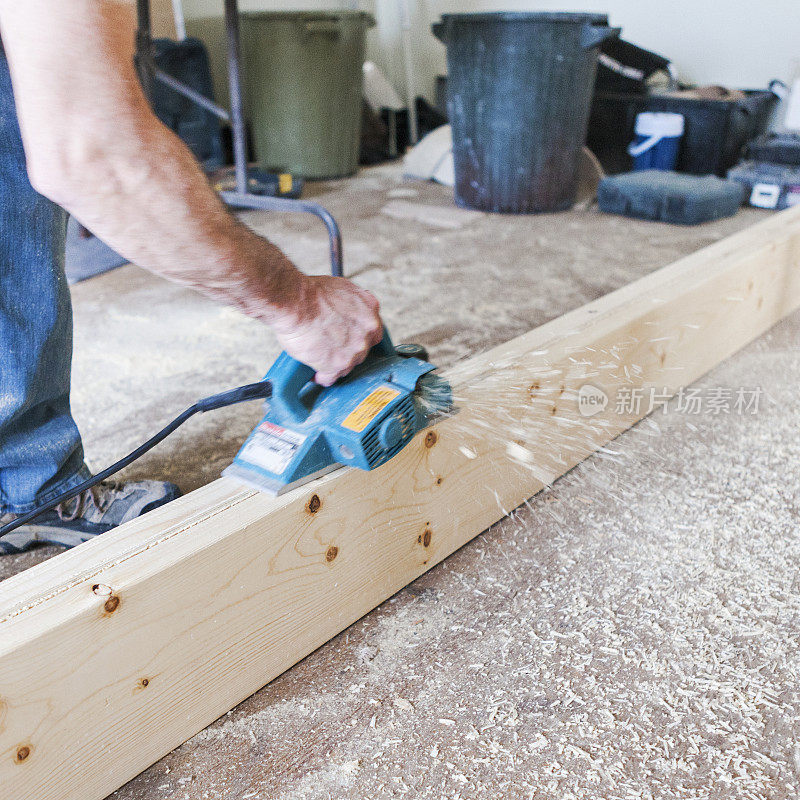 一名男子在家庭装修期间使用木质刨床