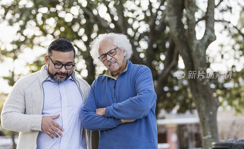 年长的西班牙人皱着眉头，儿子在说话