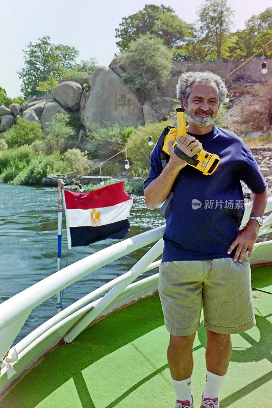 年代。一名游客乘坐旅馆的渡船横渡尼罗河。阿斯旺,埃及。
