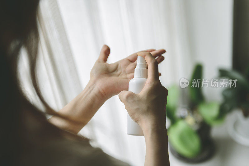 女士向手上喷洒消毒剂