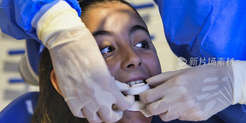 牙科检查。年轻女孩正在牙科诊所洗牙