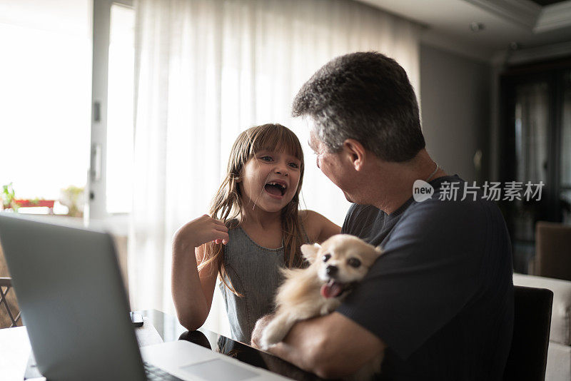 一个成熟的男人在家里牵着狗，和女儿聊天